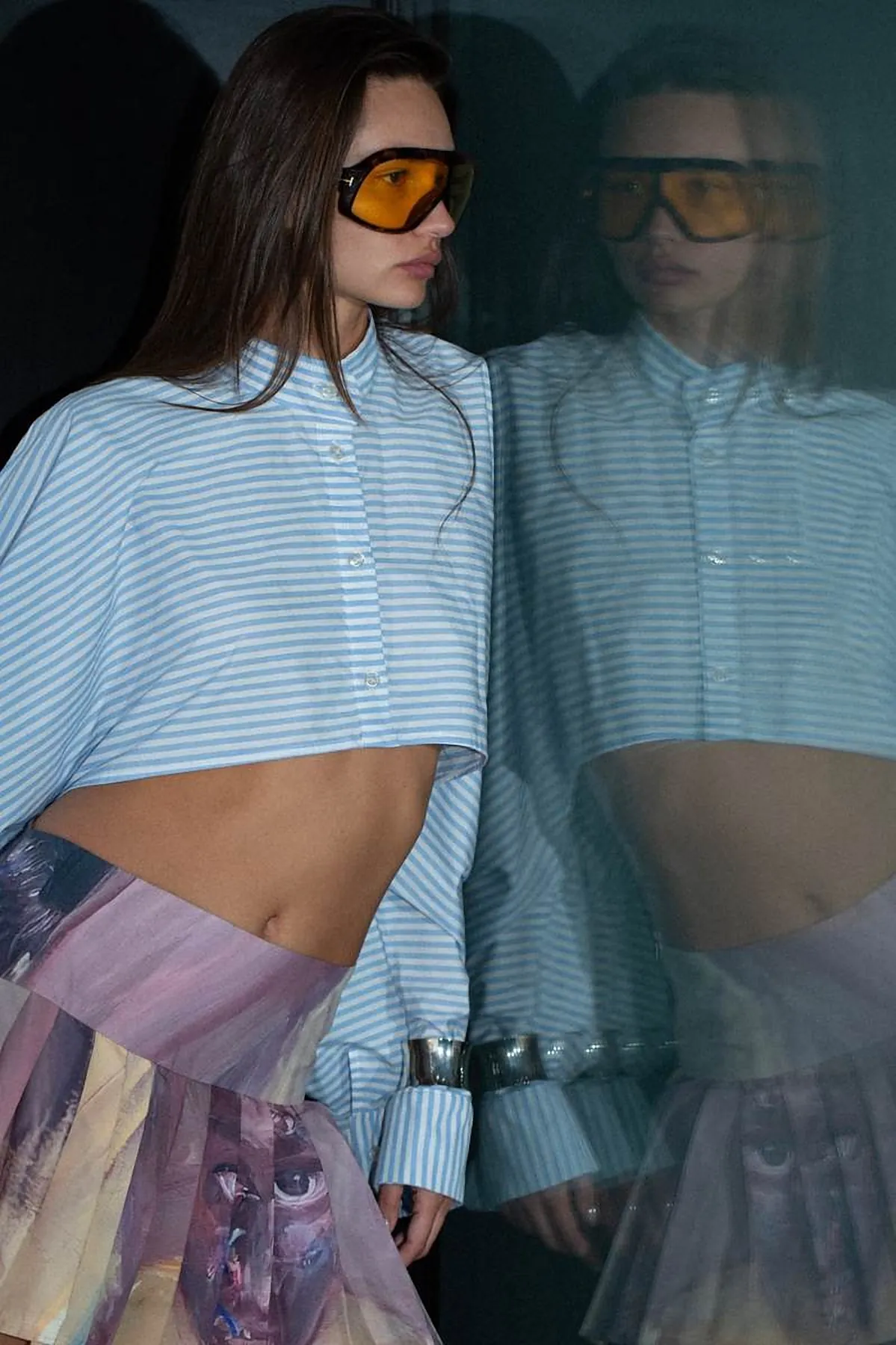Model in a striped cropped shirt and orange sunglasses with mirror reflection